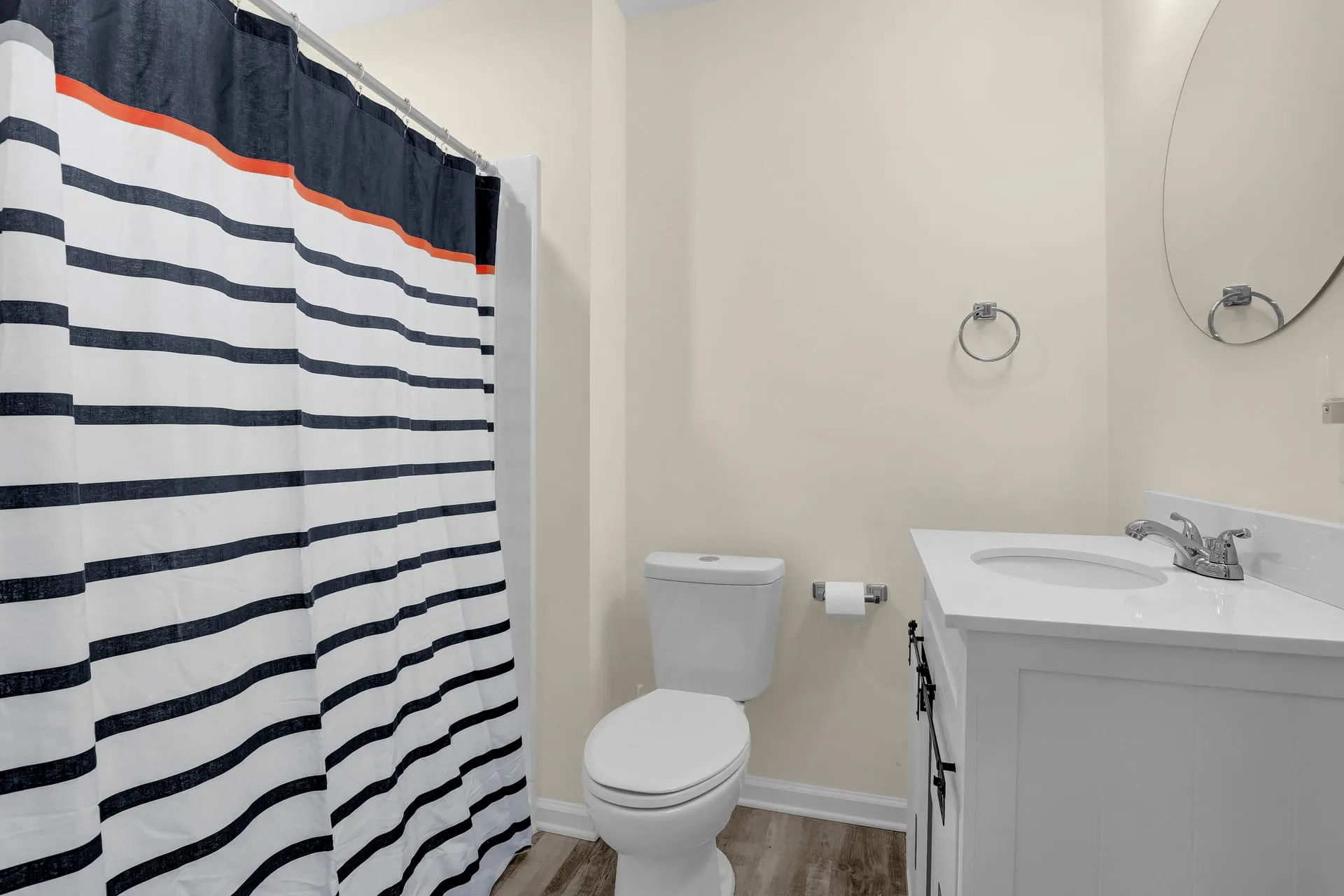 Full bathroom with navy striped shower curtain