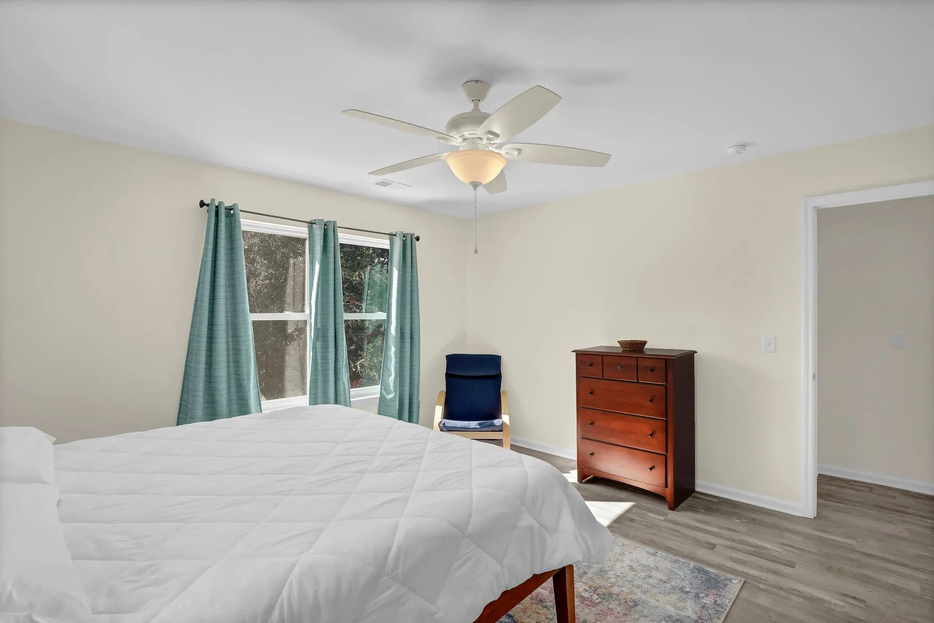 Primary king bedroom with dresser and reading chair