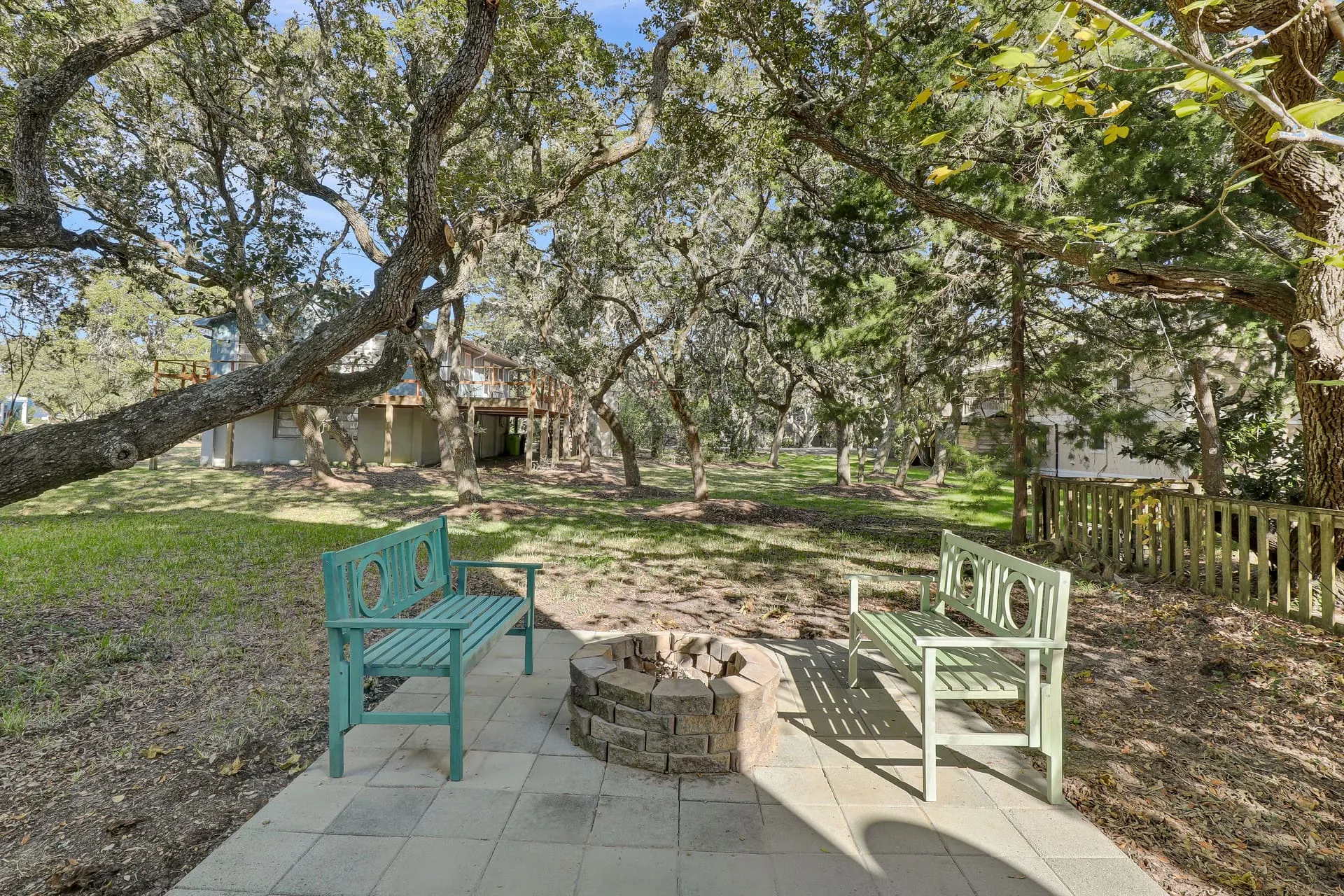 Fire pit patio with bench seating under the live oaks